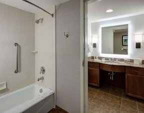 Private guest bathroom with combined shower and tub at Homewood Suites By Hilton Denton.