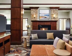 Lobby lounge area with comfortable seating, TV screen and fireplace at Hilton Garden Inn Shreveport Bossier City.