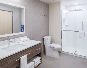 Private guest bathroom with shower and free toiletries at Home2 Suites By Hilton Cape Canaveral Cruise Port.
