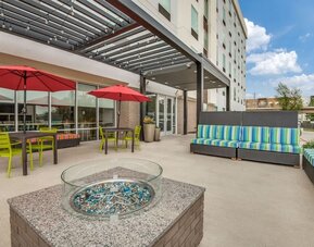 Hotel terrace with lounge seating and fire pit at Home2 Suites By Hilton Dallas Medical District Lovefield.