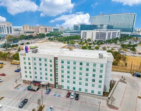 Exterior view of Home2 Suites By Hilton Dallas Medical District Lovefield and its parking area. 