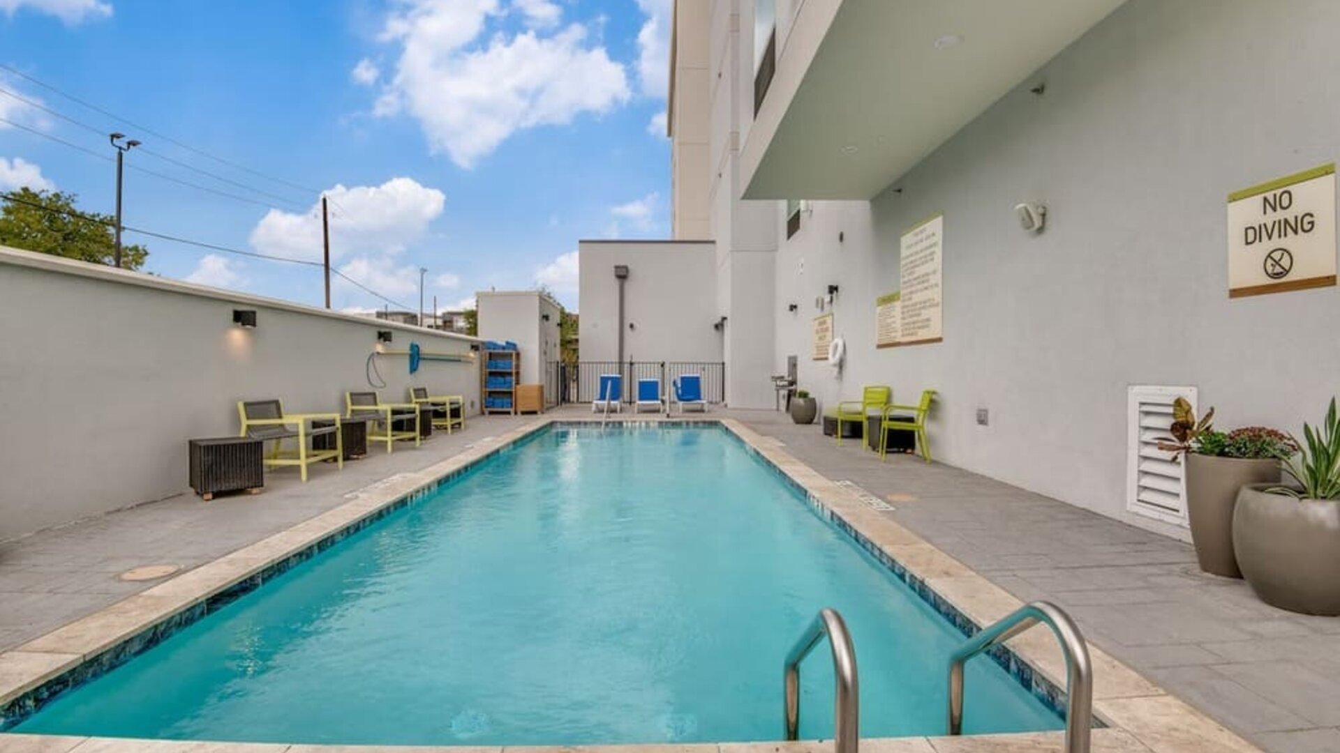 Outdoor pool with lounge chairs at Home2 Suites By Hilton Dallas Medical District Lovefield.