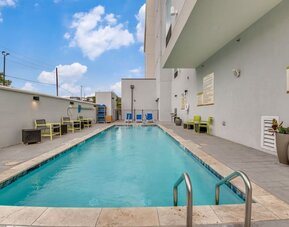 Outdoor pool with lounge chairs at Home2 Suites By Hilton Dallas Medical District Lovefield.