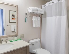 Private guest bathroom with shower and free toiletries at Sea Crest Beach Hotel.