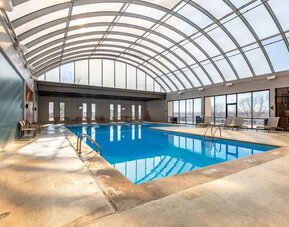 Relaxing indoor pool with lounge chairs at Wyndham Omaha.