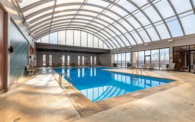 Relaxing indoor pool with lounge chairs at Wyndham Omaha.