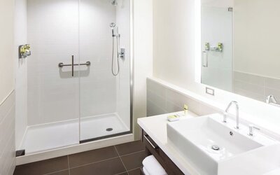 Private guest bathroom with shower and free toiletries at Element Miami International Airport.