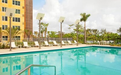 Outdoor pool with lounge chairs at Element Miami International Airport.
