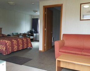 Day use room with sofa and bathtub at Milwaukie Inn Portland South.