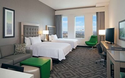 Twin bedroom with work desk and sofa at Homewood Suites By Hilton LAX Airport.