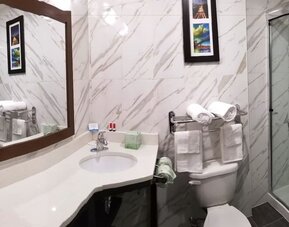 Private guest bathroom with shower and free toiletries at Days Inn By Wyndham Brooklyn Marine Park.