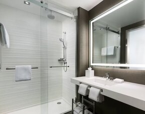 Private guest bathroom with shower and free toiletries at AC Hotel New York Times Square.