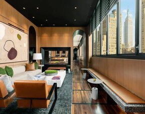 Lounge seating and workspace with fireplace at AC Hotel New York Times Square.