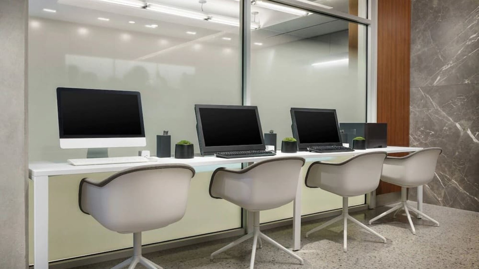 Business center with cmputers, printer and ergonomic chairs at AC Hotel New York Times Square.