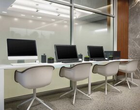 Business center with cmputers, printer and ergonomic chairs at AC Hotel New York Times Square.