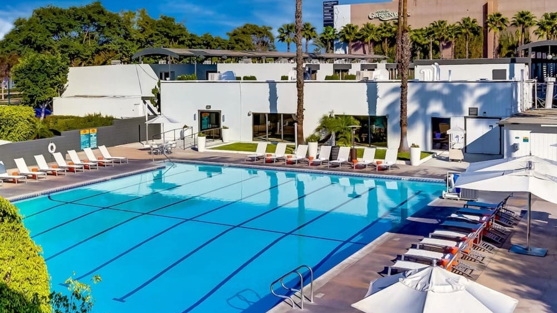 Refreshing outdoor pool surrounded by pool loungers at The Anaheim Hotel.