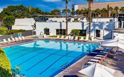 Refreshing outdoor pool surrounded by pool loungers at The Anaheim Hotel.