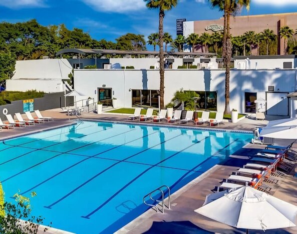 Refreshing outdoor pool surrounded by pool loungers at The Anaheim Hotel.