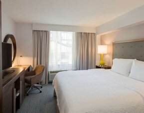 Day use room with king bed, work desk, natural light and private bathroom at Hampton Inn Manhattan Chelsea.