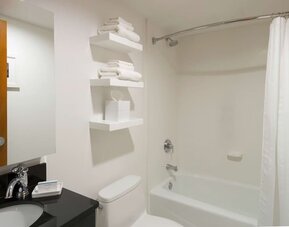Private guest bathroom with combined shower and tub at Hampton Inn Manhattan - Madison Square Garden.