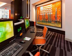 Business center with computers, printer and ergonomic chairs at Courtyard By Marriott New York Manhattan/Central Park.