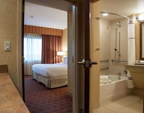 Guest bathroom with tub and shower at Embassy Suites By Hilton Charlotte-Concord-Golf Resort & Spa.