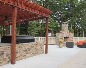 Outdoor furniture and grill area at Embassy Suites By Hilton Charlotte-Concord-Golf Resort & Spa.