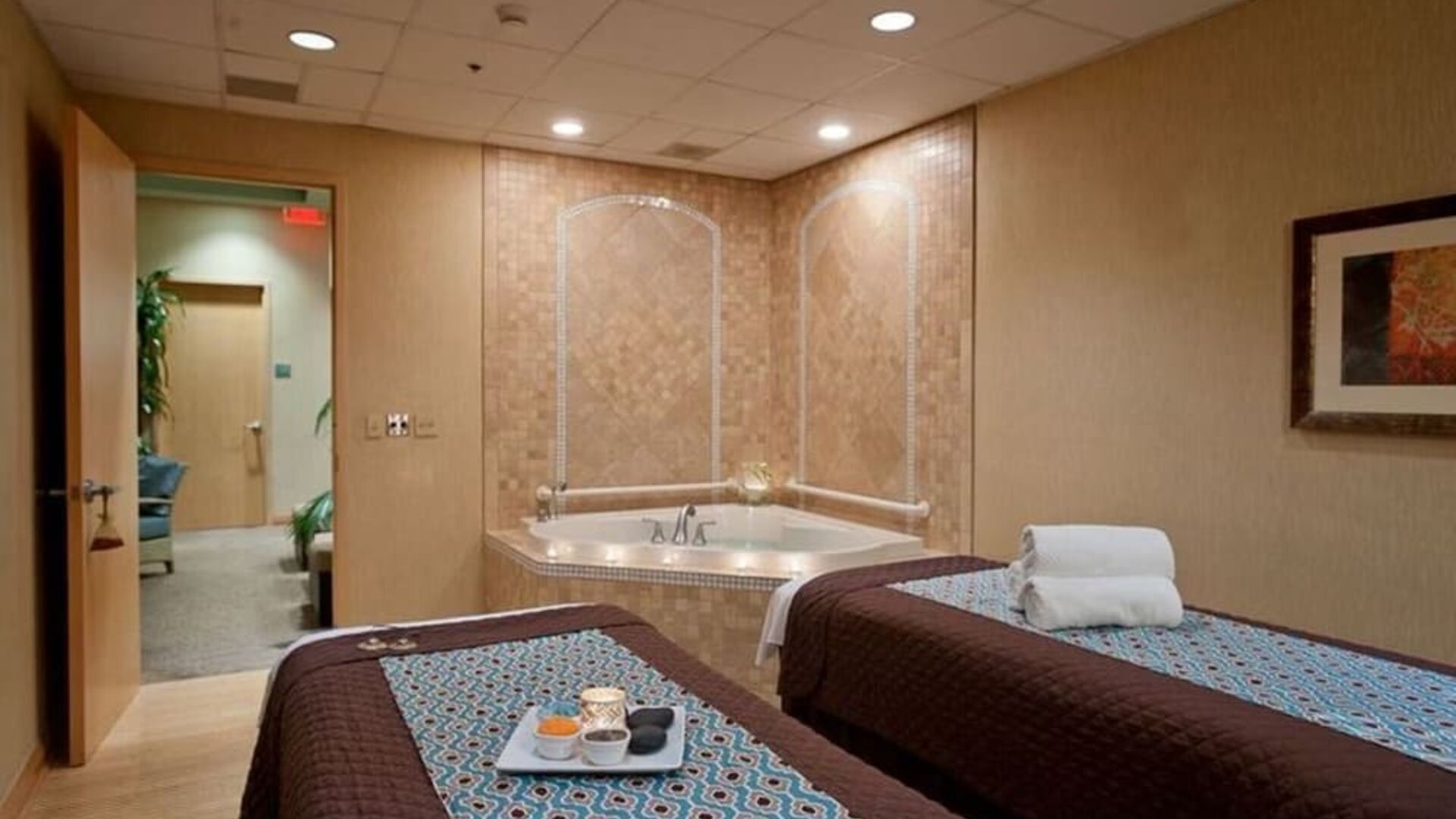 Spa with jacuzzi and massage tables at Embassy Suites By Hilton Charlotte-Concord-Golf Resort & Spa.