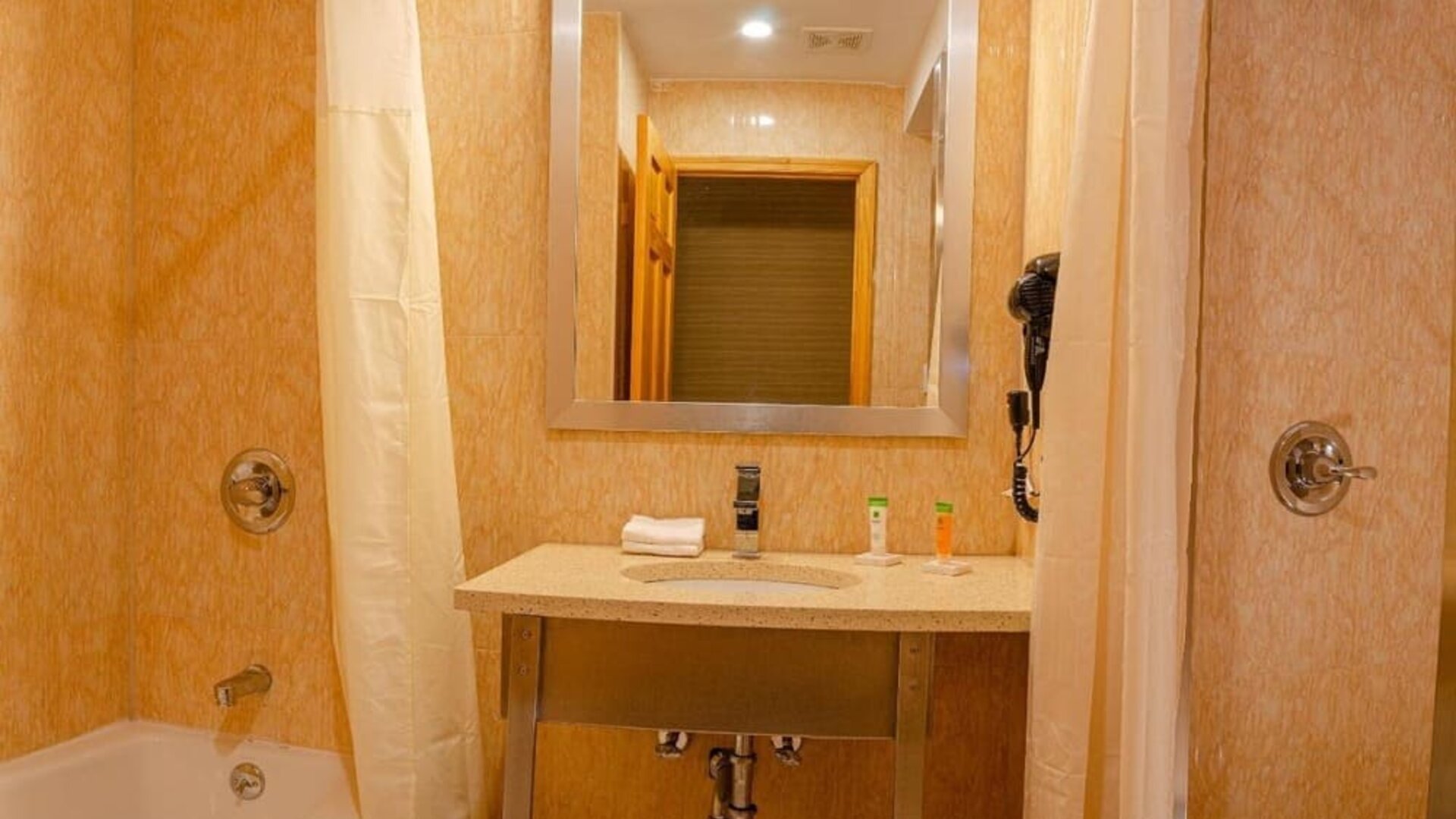 Private guest bathroom with combined shower and tub at Elmhurst Hotel.