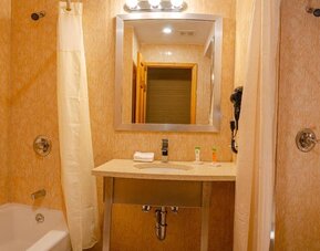 Private guest bathroom with combined shower and tub at Elmhurst Hotel.