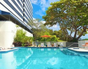 Outdoor pool with lounge chairs at Sheraton Miami Airport Hotel.