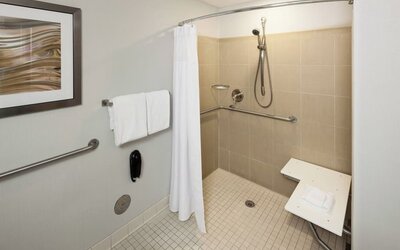 Private guest bathroom with accesible shower and free toiletries at Courtyard Miami Dolphin Mall.