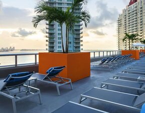 Rooftop terrace with lounge seating and beatiful seaside view at Hyatt Centric Brickell Miami.