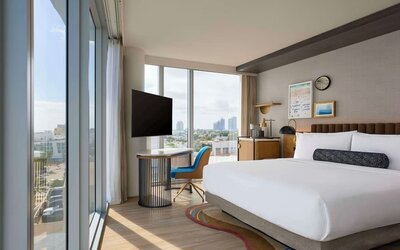 King room with floor to ceiling windows, work desk, TV screen and private bathroom at Hyatt Centric Miami South Beach.
