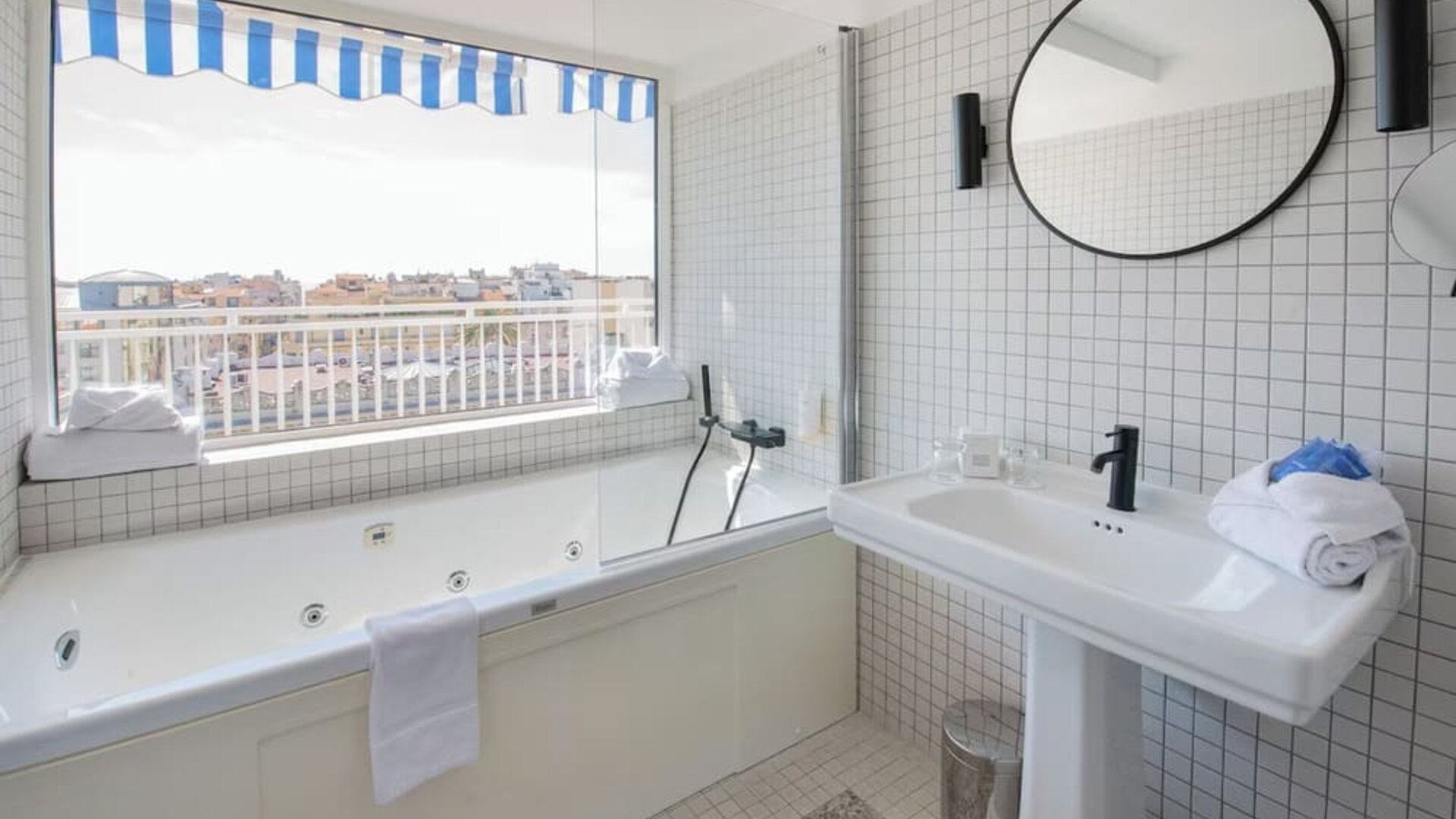 Guest bathroom with tub and natural light at Splendid Hotel & Spa Nice.