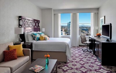 Day use room with TV, work desk, sofa and natural light at Courtyard San Diego Downtown.