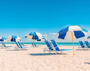 Beach access with lounge seating and umbrellas at The Goodtime Hotel.