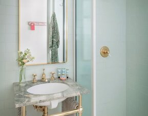 Private bathroom with shower and free toiletries at The Goodtime Hotel.