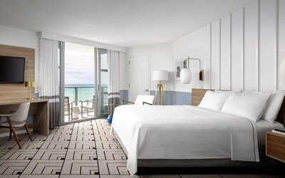 Day use room with king bed, work desk, balcony and private bathroom at Cadillac Hotel & Beach Club, Autograph Collection.