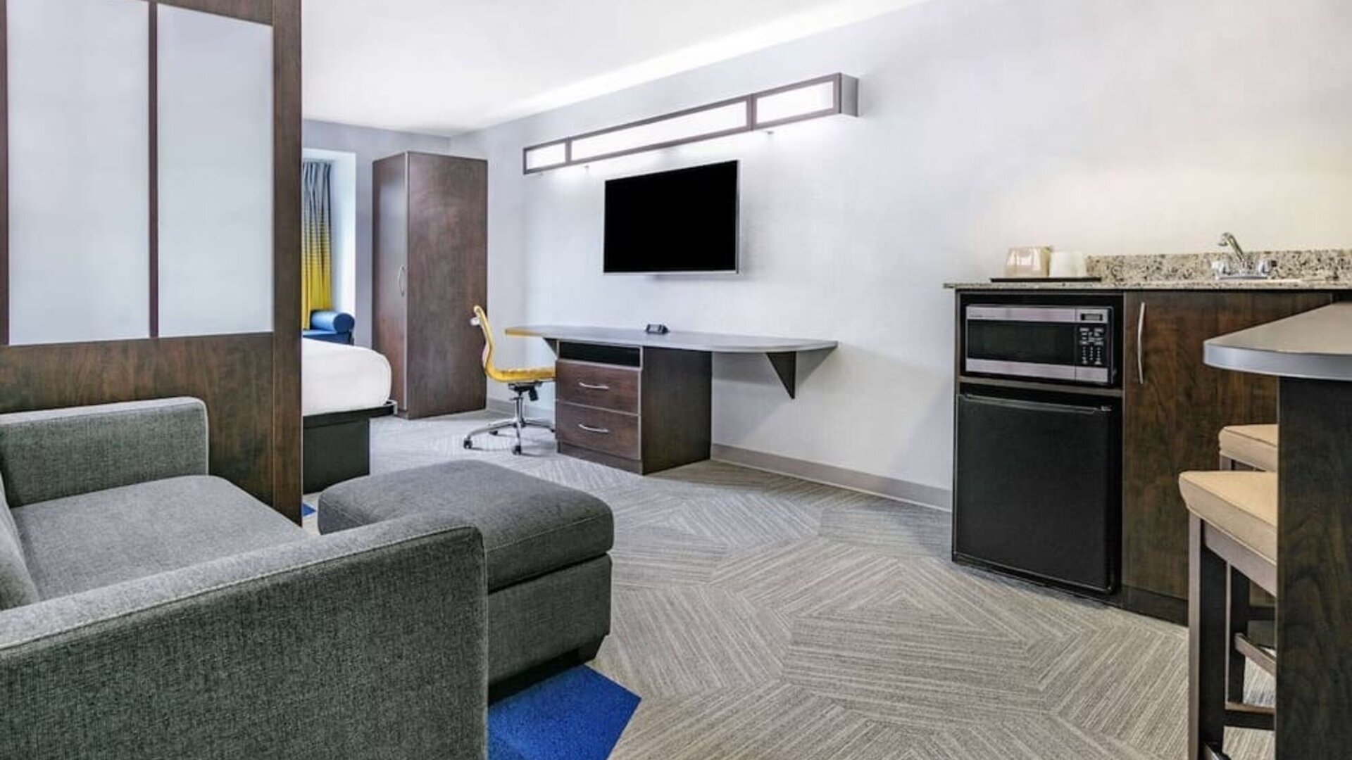 Day use room with TV and work desk at Microtel Inn And Suites By Wyndham Austin Airport.