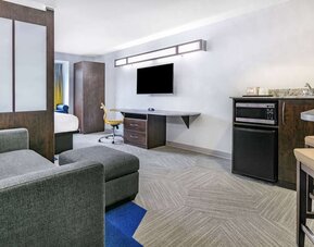 Day use room with TV and work desk at Microtel Inn And Suites By Wyndham Austin Airport.