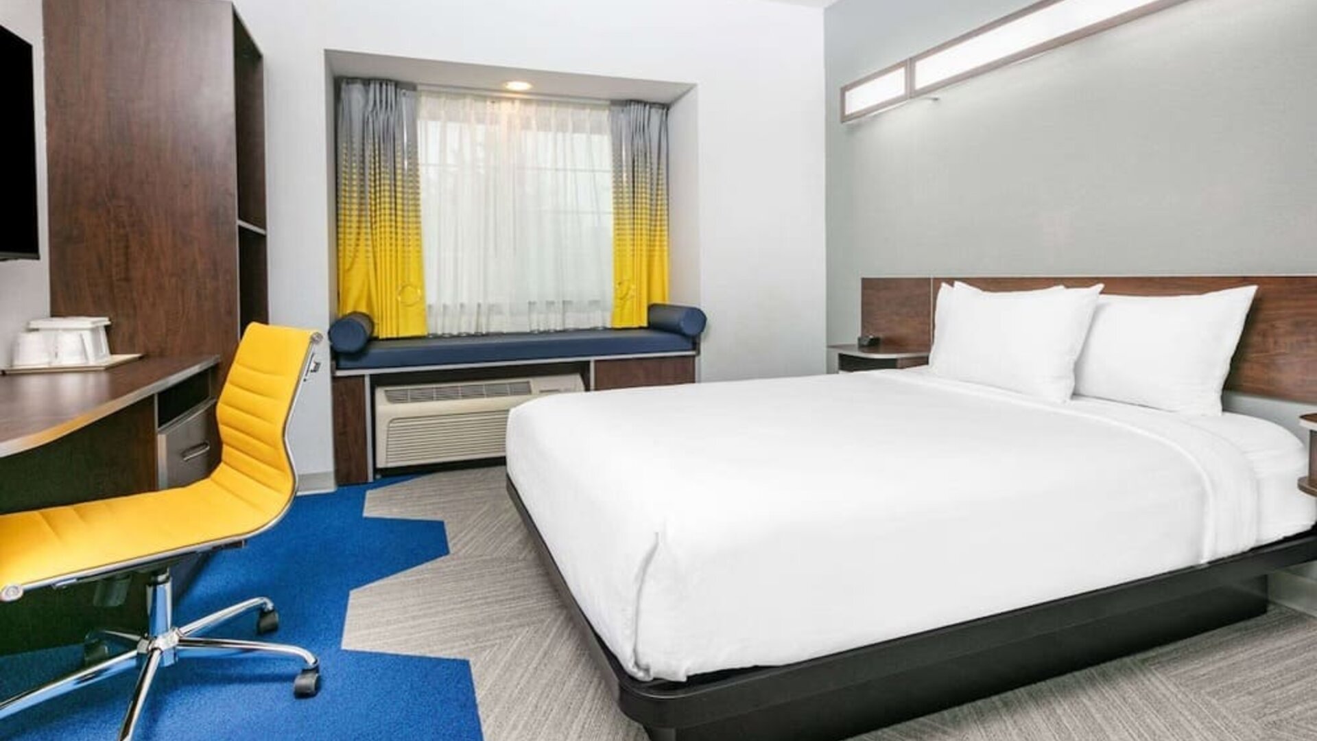 Day use room with TV and work desk at Microtel Inn And Suites By Wyndham Austin Airport.