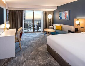 King bedroom with desk and balcony at Hyatt Regency San Francisco.
