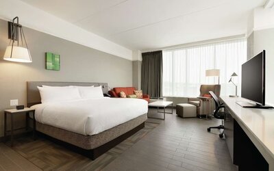 Delux king room with sofa, work desk and TV at Hilton Garden Inn Calgary Downtown.