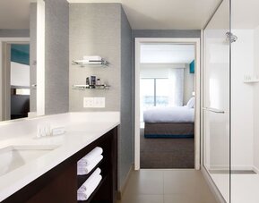 Private guest bathroom with shower and free toiletries at Residence Inn By Marriott LAX Airport.
