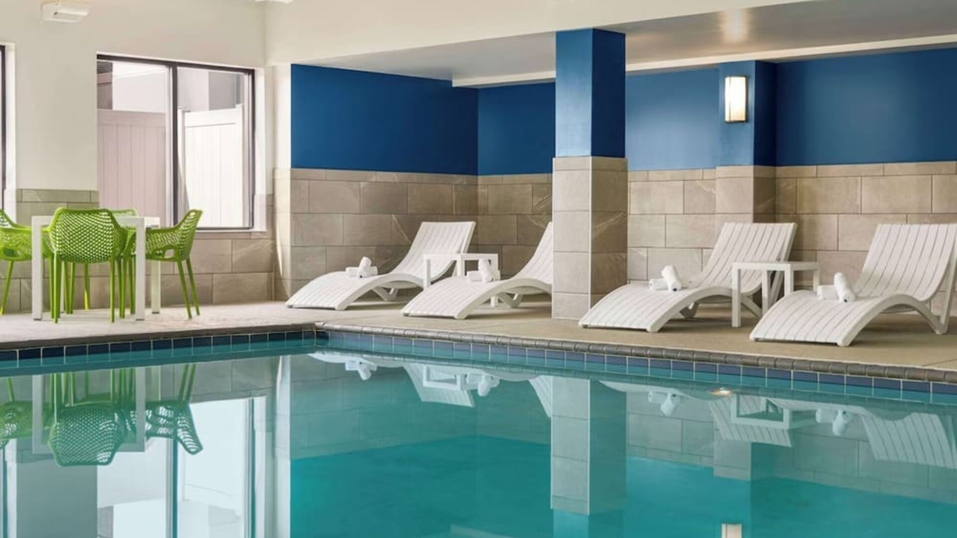 Indoor pool with lounge chairs at Hampton Inn Chicago-O'Hare International Airport.