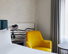 King room with chair at Leonardo Hotel Dublin Christchurch.