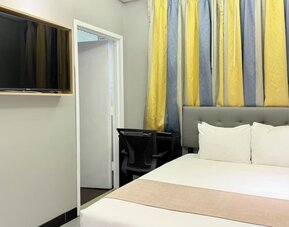 Madison LES Hotel room with double bed, and desk for working.