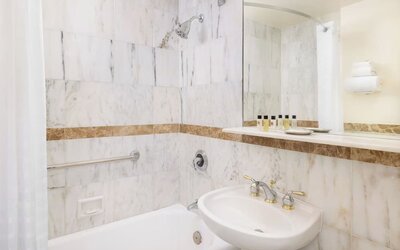 Modern bathroom with plush towels at New Yorker by Lotte Hotels