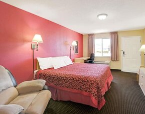 Day room with work desk and couch at Days Inn By Wyndham East Albuquerque.